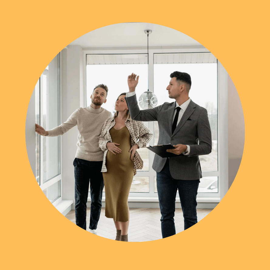 un couple et un agent immobilier qui visitent un appartement